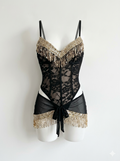A black lace bodysuit with gold fringe